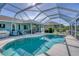 Enclosed pool area with a sparkling pool, patio furniture, and a covered seating area perfect for outdoor relaxation at 5 Pine Valley Rd, Rotonda West, FL 33947
