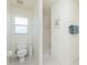 Bathroom featuring a toilet, shower and window with neutral wall color and tile floor at 51 Mark Twain Ln, Rotonda West, FL 33947