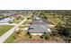 The back and side view of the residence shows a well-maintained lawn with trees and manicured landscaping at 51 Mark Twain Ln, Rotonda West, FL 33947