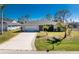Charming single-Gathering home with a well-kept lawn, mature trees, and a paved driveway at 51 Mark Twain Ln, Rotonda West, FL 33947