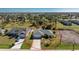 Charming single-story home featuring a well-manicured lawn, mature trees, and an extended driveway at 51 Mark Twain Ln, Rotonda West, FL 33947