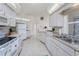 Bright kitchen with white cabinets, tile floors, and ample counter space for cooking at 51 Mark Twain Ln, Rotonda West, FL 33947