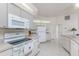 Bright kitchen with white cabinets, tile floors, and appliances, perfect for home cooking at 51 Mark Twain Ln, Rotonda West, FL 33947