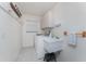 Functional laundry room with a utility sink, a washer and dryer, storage cabinets, and tile floors at 51 Mark Twain Ln, Rotonda West, FL 33947