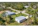 Aerial view of the property featuring a detached garage, landscaped yard, and tree coverage at 5258 Grassland Ter, Port Charlotte, FL 33981