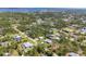 An aerial view showcases a neighborhood with mature trees and a beautiful lake in the distance at 5258 Grassland Ter, Port Charlotte, FL 33981