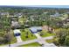 Aerial view of a single-Gathering home with a well-maintained lawn, mature trees, and a detached garage at 5258 Grassland Ter, Port Charlotte, FL 33981