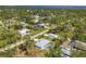 Aerial view of the neighborhood showcasing houses, tree coverage and a distant water view at 5258 Grassland Ter, Port Charlotte, FL 33981