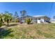 Beautiful backyard showcasing a screened-in lanai, mature trees, and well-maintained lawn, ideal for relaxation at 5258 Grassland Ter, Port Charlotte, FL 33981
