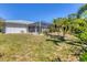 Expansive backyard featuring a screened lanai and lush tropical landscaping, perfect for outdoor entertaining at 5258 Grassland Ter, Port Charlotte, FL 33981
