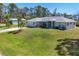 A well-maintained home with a lush green lawn, a detached garage, and a beautifully landscaped yard at 5258 Grassland Ter, Port Charlotte, FL 33981