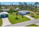 Charming single-Gathering home featuring a well-manicured lawn, mature palm trees, and a detached garage at 5258 Grassland Ter, Port Charlotte, FL 33981