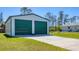 Spacious detached two-car garage with green doors and a long driveway, providing ample parking at 5258 Grassland Ter, Port Charlotte, FL 33981