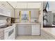 Well-lit kitchen with white appliances and a garden window above the sink, and neutral cabinets at 5258 Grassland Ter, Port Charlotte, FL 33981