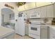 Bright kitchen with white cabinets and appliances, and archway leading to the breakfast nook at 5258 Grassland Ter, Port Charlotte, FL 33981