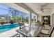 Screened-in patio with a dining table and chairs, offering views of the swimming pool and backyard at 5258 Grassland Ter, Port Charlotte, FL 33981