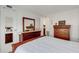 Cozy bedroom with two wood dressers, white bedding, white walls and light at 5619 Bayshore Rd # 240, Palmetto, FL 34221