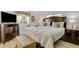 Bright bedroom featuring a large bed with decorative pillows, TV, dresser and an ottoman at 5619 Bayshore Rd # 240, Palmetto, FL 34221