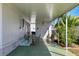 Covered patio featuring outdoor dining set and relaxing sitting chairs with greenery on a sunny day at 5619 Bayshore Rd # 240, Palmetto, FL 34221