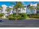 Exterior view of a white condo building surrounded by lush, manicured landscaping and tropical palm trees at 5858 Gasparilla Rd # Mm40, Boca Grande, FL 33921