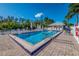 Community pool featuring a clear, inviting blue swimming pool with chairs, umbrellas, and palm trees at 5858 Gasparilla Rd # Mm40, Boca Grande, FL 33921