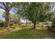 Scenic backyard featuring mature trees, green lawn, and a tranquil bench, perfect for relaxation at 587 Viridian St, Englewood, FL 34223