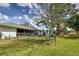 Fenced backyard showcasing a well-maintained lawn, shade trees, and a cozy seating area at 587 Viridian St, Englewood, FL 34223