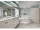 Bathroom featuring a soaking tub, dual vanity, and tiled floors at 587 Viridian St, Englewood, FL 34223