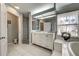 Bright bathroom featuring a double sink vanity, walk-in shower, and tiled floors at 587 Viridian St, Englewood, FL 34223