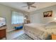 This bedroom features wood-look flooring, a ceiling fan, a bed, and natural light at 587 Viridian St, Englewood, FL 34223