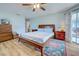 This bedroom features wood floors, ceiling fan, and access to a balcony at 587 Viridian St, Englewood, FL 34223