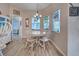 Bright dining room with a round table, accent cabinet, and natural light from colorful stained-glass windows at 587 Viridian St, Englewood, FL 34223