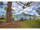 Well-maintained home exterior featuring a shed, lush lawn, and mature trees creates a peaceful setting at 587 Viridian St, Englewood, FL 34223