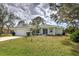 Charming single-story home featuring a manicured lawn, attached garage, and welcoming front entrance at 587 Viridian St, Englewood, FL 34223