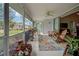 Inviting screened-in patio with potted plants, a rocking chair, and comfortable seating area at 587 Viridian St, Englewood, FL 34223