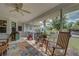 Charming screened-in patio with rocking chair and multiple displays of potted plants and decor at 587 Viridian St, Englewood, FL 34223