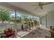 Bright screened-in patio featuring a colorful rug, rocking chair, and lovely garden view at 587 Viridian St, Englewood, FL 34223