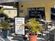 Exterior view of Vino Loco, a restaurant and wine bar with outdoor seating and lush potted plants at 587 Viridian St, Englewood, FL 34223