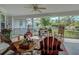 Cozy screened-in porch with comfortable seating and views of the private backyard and landscaping at 587 Viridian St, Englewood, FL 34223