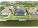 An aerial view highlights the property's backyard oasis, including the screened lanai, pool, and private dock on the canal at 8144 Antwerp Cir, Port Charlotte, FL 33981