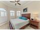Bedroom featuring a large window with shutters, a ceiling fan, and a decorative wooden bed frame at 8144 Antwerp Cir, Port Charlotte, FL 33981