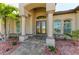 Elegant entrance with stone pillars, a decorative stone walkway, and lush landscaping at 8144 Antwerp Cir, Port Charlotte, FL 33981