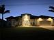 Charming home illuminated at night showcasing the architectural details, landscaping, and inviting ambiance at 8144 Antwerp Cir, Port Charlotte, FL 33981