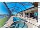 An outdoor kitchen and seating area is adjacent to the screened-in pool and spa at 8144 Antwerp Cir, Port Charlotte, FL 33981