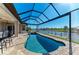 Inviting in-ground pool with a screened enclosure, offering a relaxing outdoor space with a scenic water view at 8144 Antwerp Cir, Port Charlotte, FL 33981