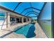 Inviting in-ground pool with a screened enclosure, offering a relaxing outdoor space with a lovely water view at 8144 Antwerp Cir, Port Charlotte, FL 33981