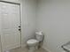 Bathroom with a toilet, roll of toilet paper, and a white door at 9172 Ravel St, Port Charlotte, FL 33981
