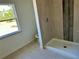 Bathroom featuring a shower with modern tile and a toilet by a window at 9172 Ravel St, Port Charlotte, FL 33981
