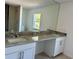 Bathroom featuring double sinks, granite countertop, and large mirror at 9172 Ravel St, Port Charlotte, FL 33981