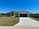 Charming single-story home features a two-car garage, well-maintained lawn, and a concrete driveway at 9172 Ravel St, Port Charlotte, FL 33981